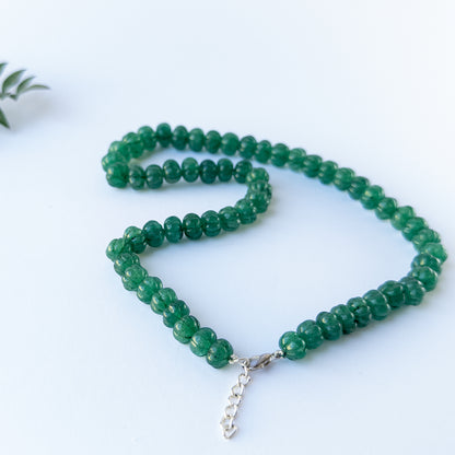 Genuine gemstone beads in Emerald showing carved brilliance and quality craftsmanship in a necklace design.