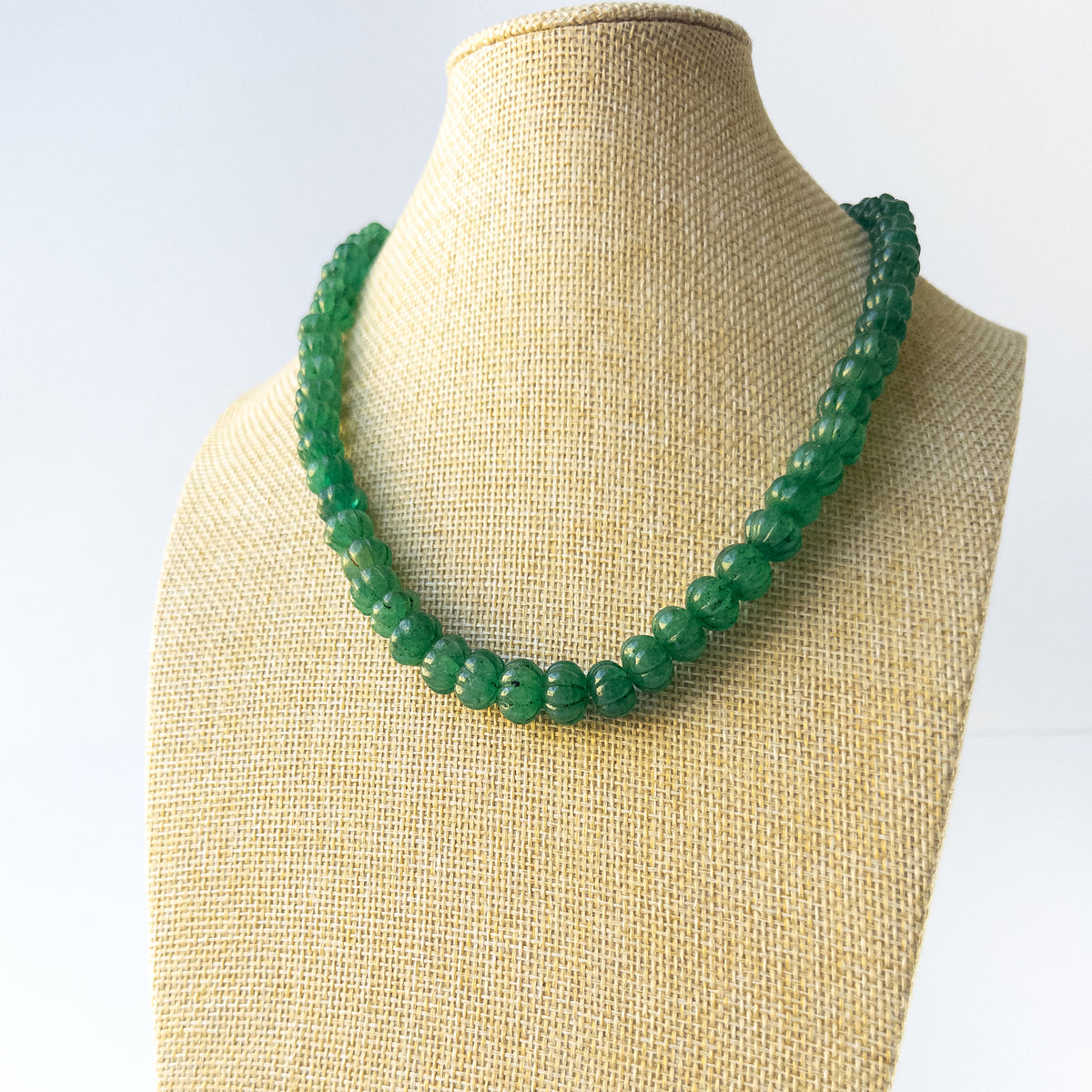 Authentic Emerald gemstone necklace displaying natural colour, carved detailing, and premium clarity.