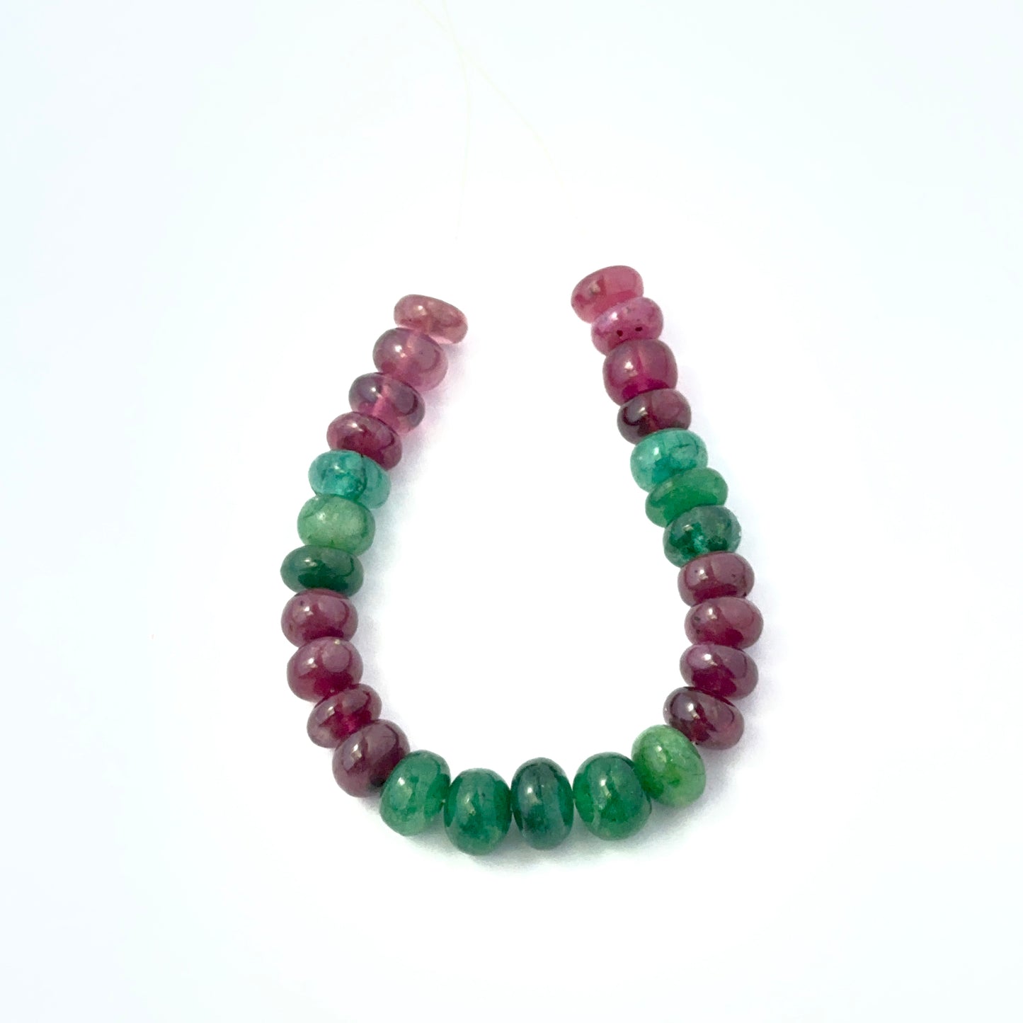 Emerald and Ruby smooth rondelle beads aligned together, highlighting colour contrast and quality stone beads.