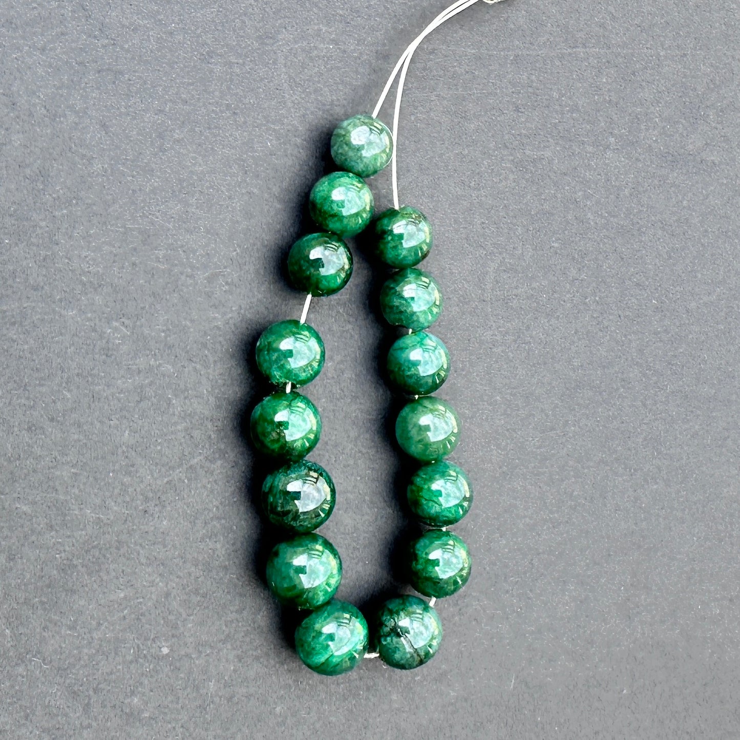 Emerald smooth rondelle beads in 8-9mm size with polished finish and rich green tones for handmade jewellery components.