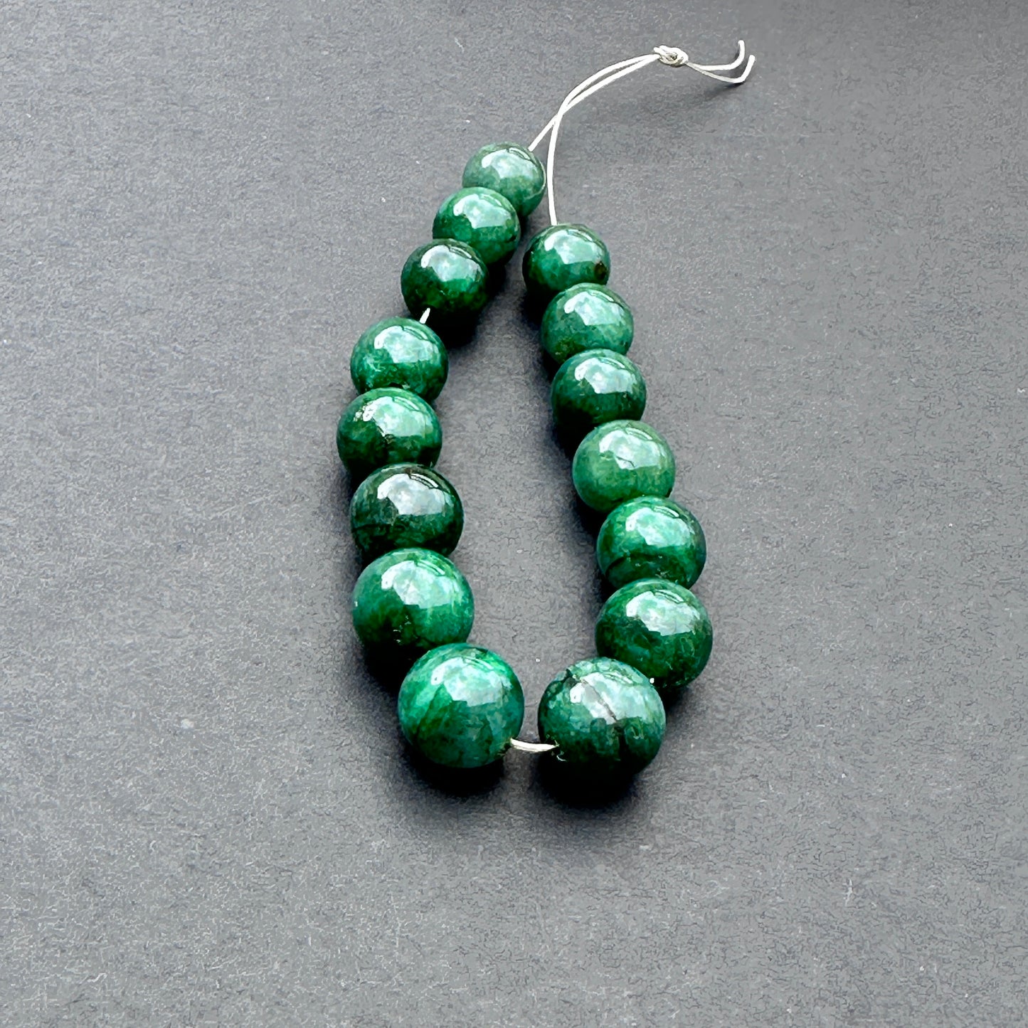 Emerald smooth rondelle beads in 8-9mm size with polished finish and rich green tones for handmade jewellery components.