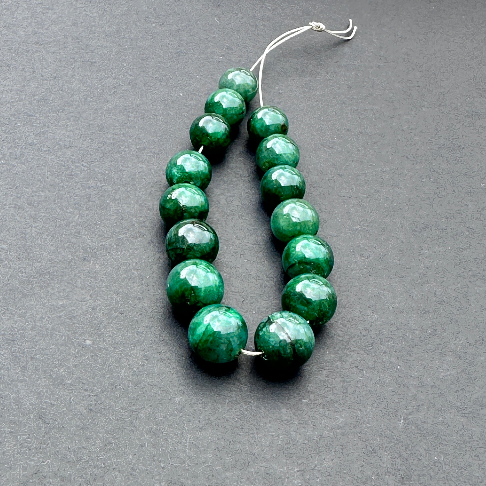 Emerald smooth rondelle beads in 8-9mm size with polished finish and rich green tones for handmade jewellery components.