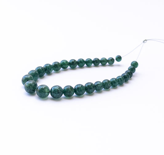 Close‑up of Emerald smooth round beads with rich green tones and glossy shine.
