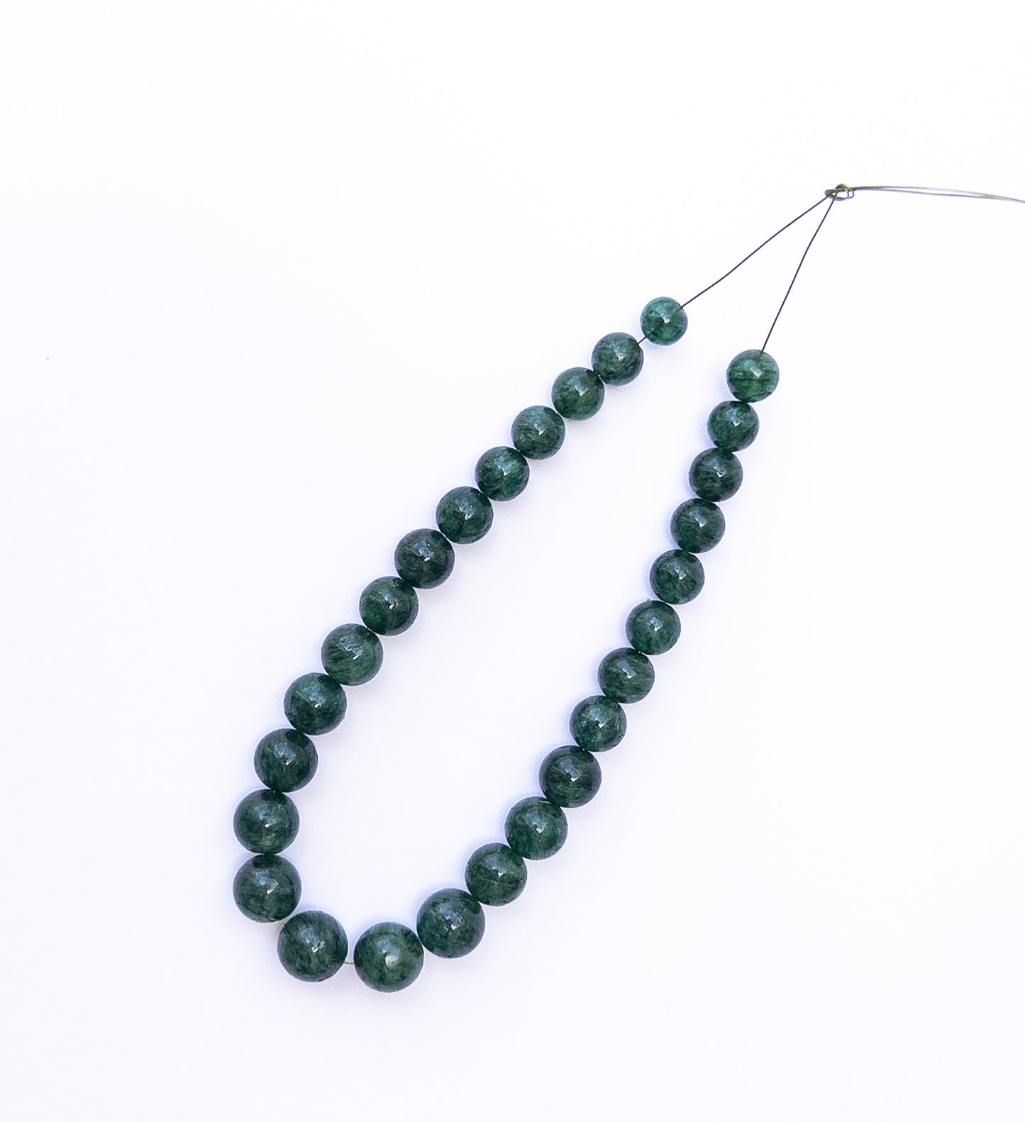 Emerald smooth round beads arranged neatly, highlighting their 6.3–8.5mm size.