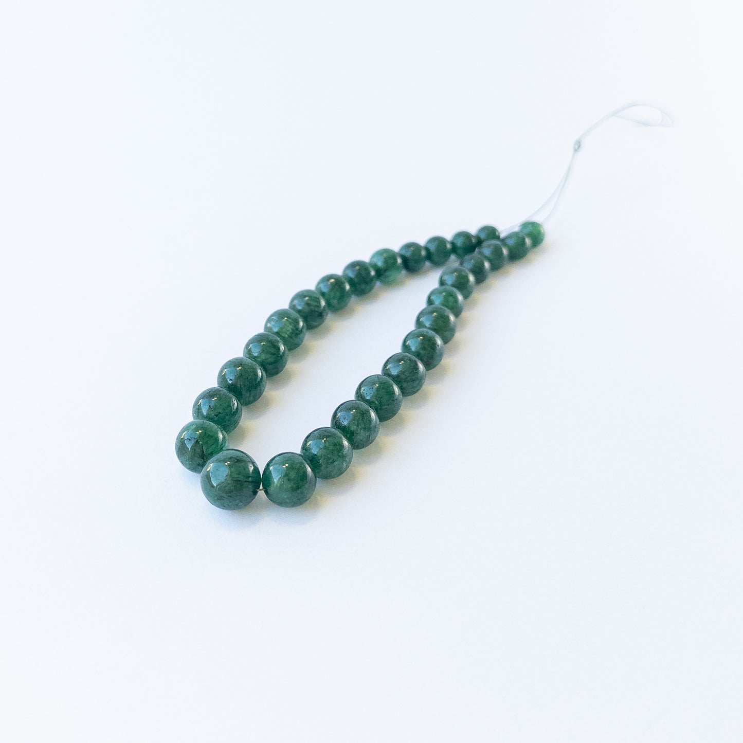 Genuine Emerald smooth round gemstone beads showcasing rich green colour and polished shine.