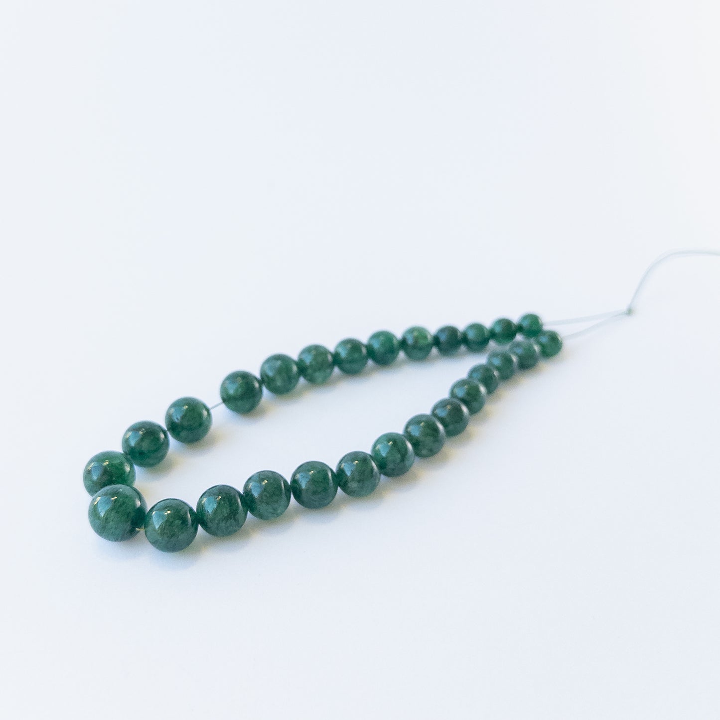 Emerald gemstone beads for jewellery design showing glossy surfaces and natural clarity.
