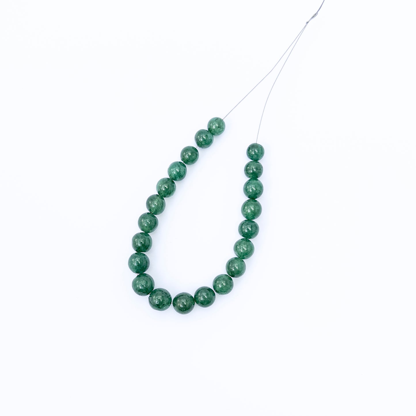 Close‑up of Emerald round gemstone beads highlighting their glossy finish and vibrant natural tones.