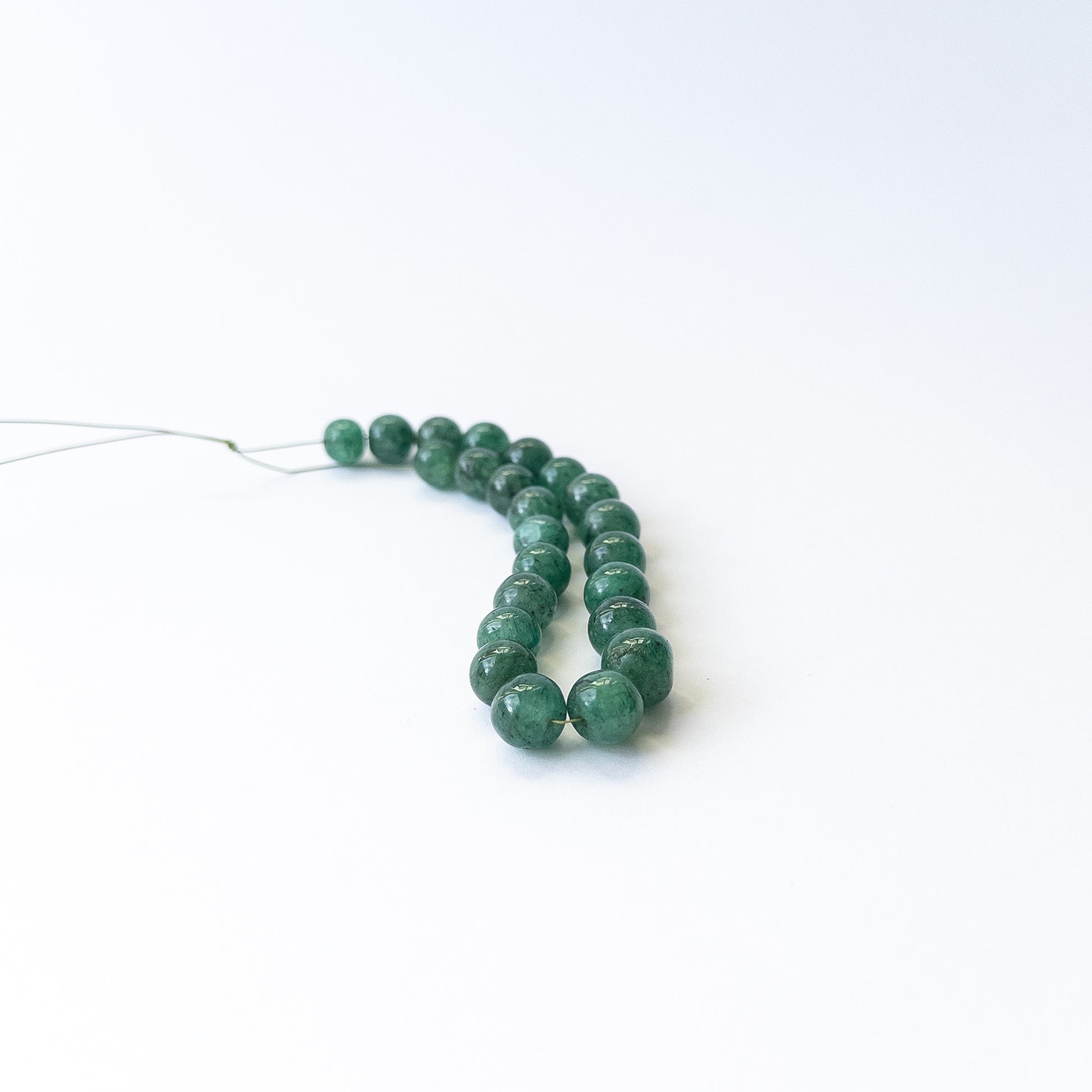 Emerald smooth round gemstone beads in 7–9mm sizes, genuine stones for handmade jewellery.