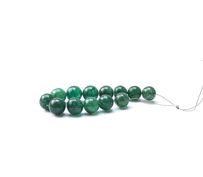 Close‑up of Emerald smooth round beads with rich green tones and glossy shine.