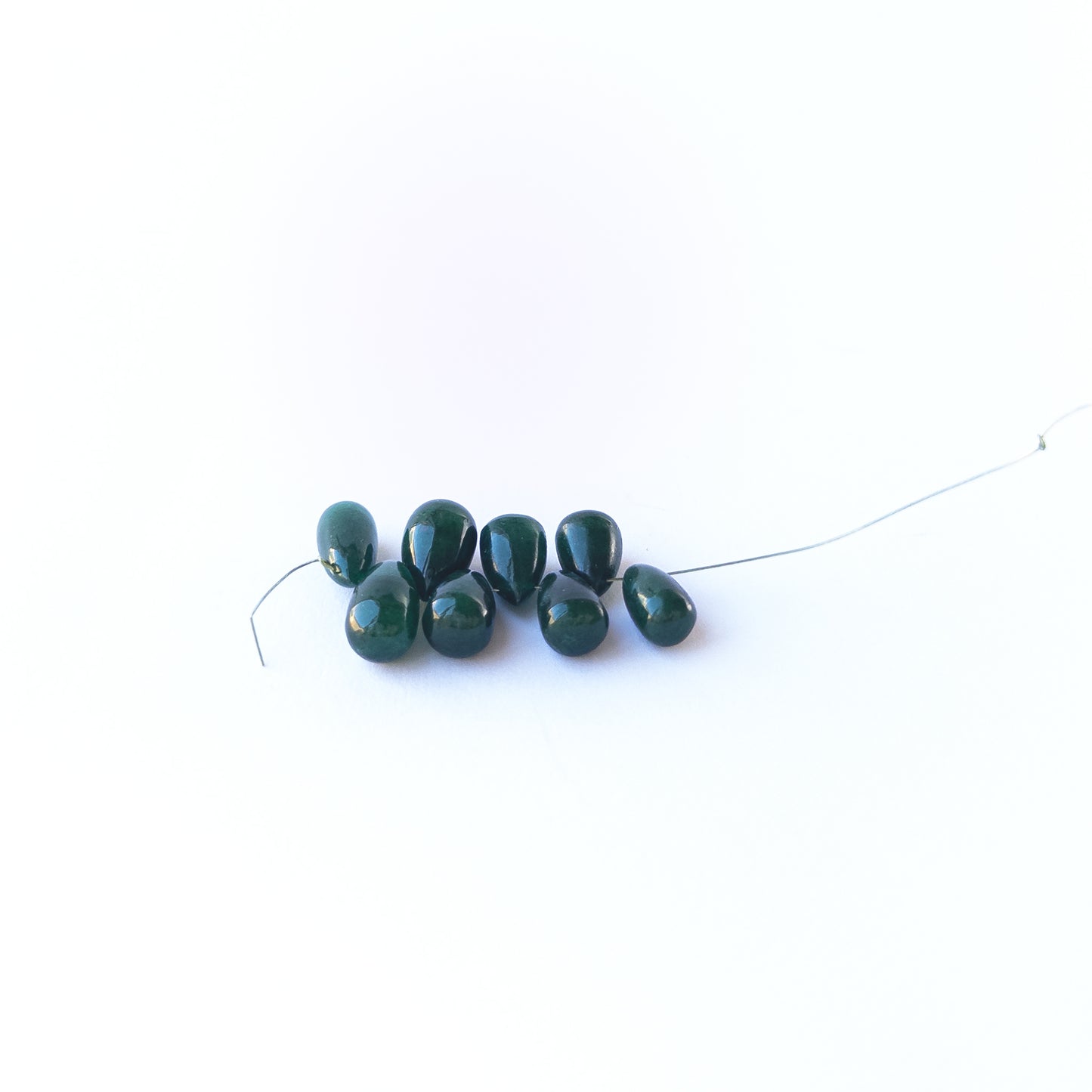 Smooth Emerald briolette beads with refined shaping and glossy finish.