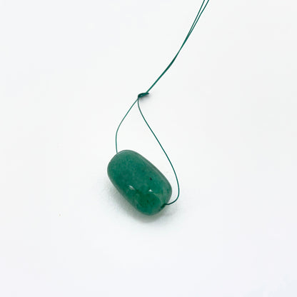 Emerald tumble-drilled gemstone showing rich green colour and texture for handmade jewellery.