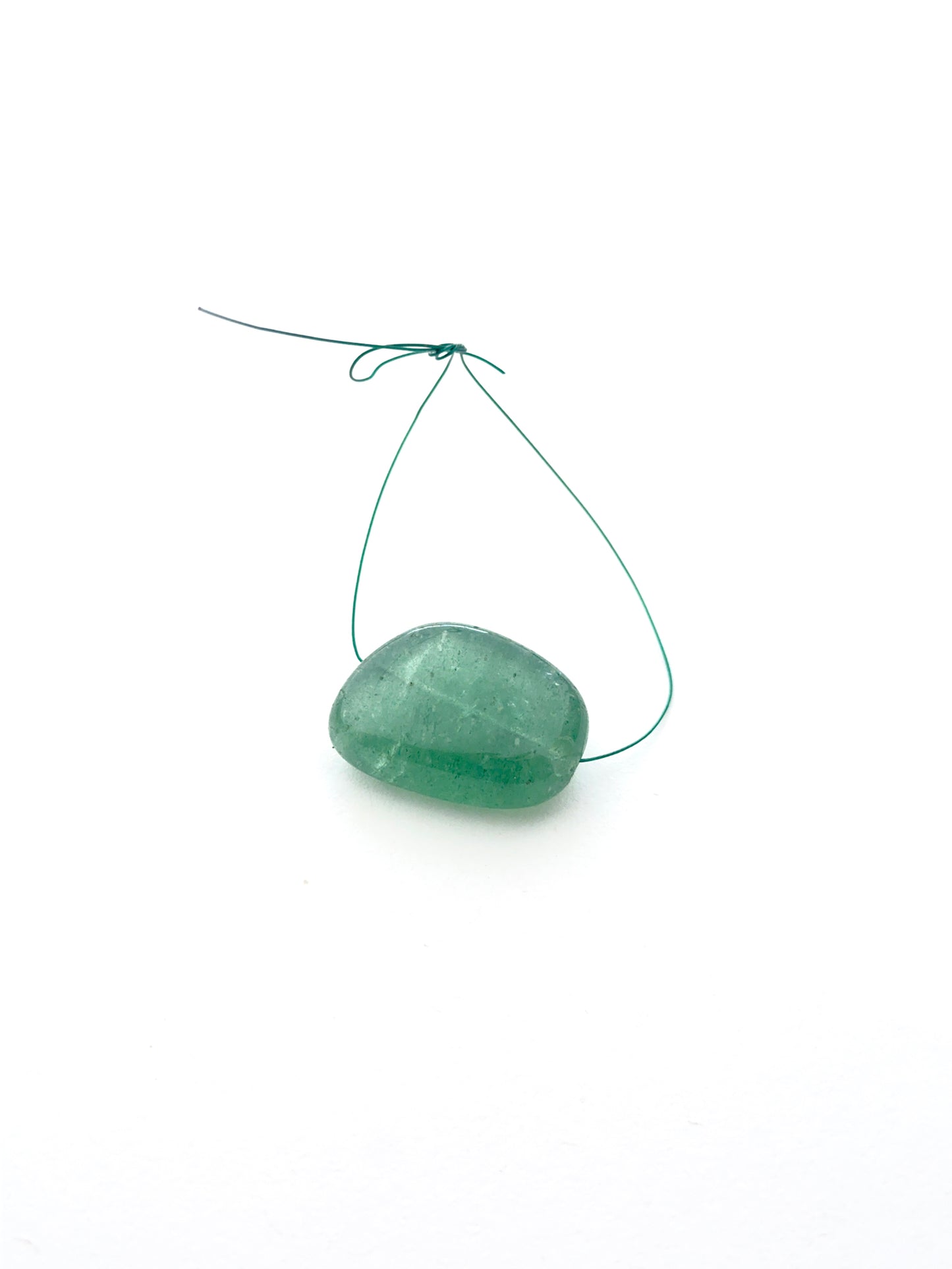 Close-up of emerald tumble bead highlighting its polished surface and gemstone inclusions.