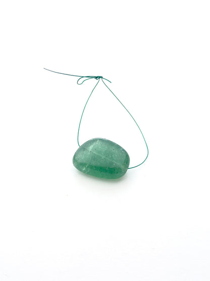 Close-up of emerald tumble bead highlighting its polished surface and gemstone inclusions.