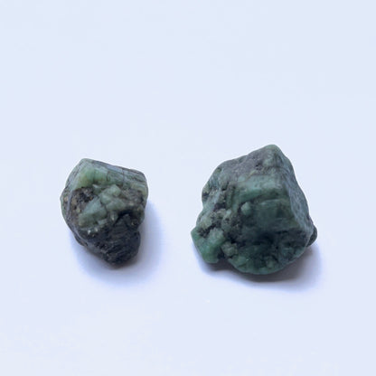 Close‑up of emerald undrilled stones on white background.