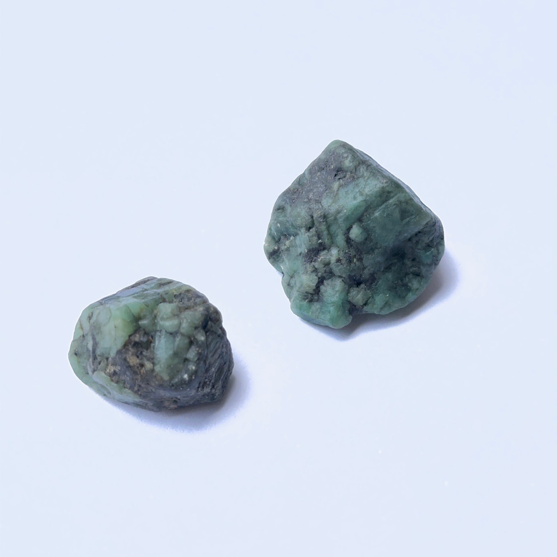 Raw emerald gemstone showing raw texture and deep green colour in a 25–28mm size.