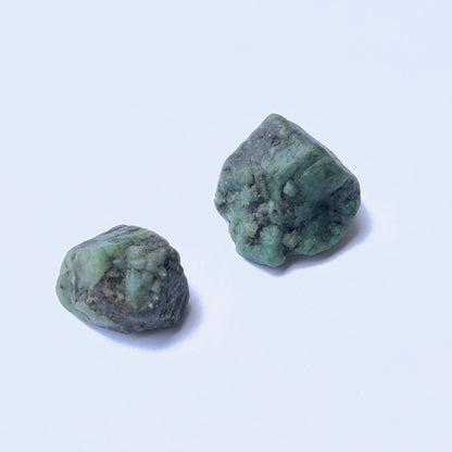 Raw emerald gemstone showing raw texture and deep green colour in a 25–28mm size.