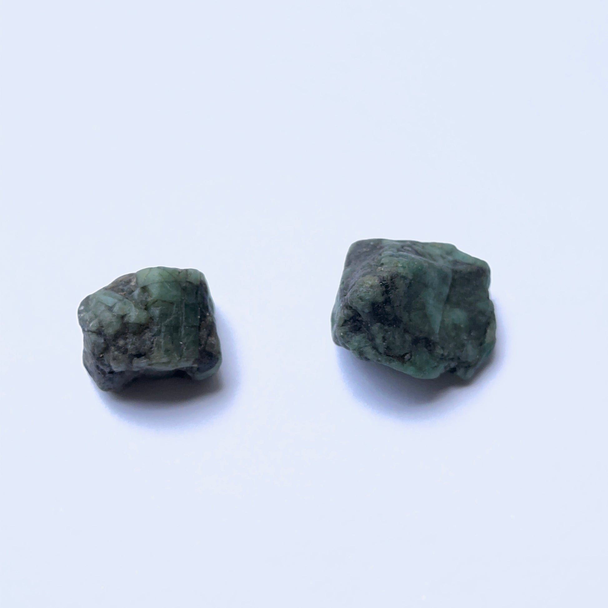  Undrilled emerald rough stone with organic surface and rich green tones.