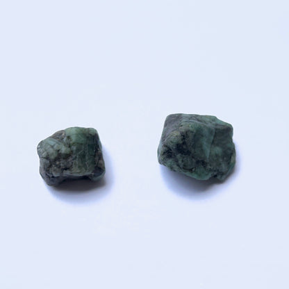  Undrilled emerald rough stone with organic surface and rich green tones.