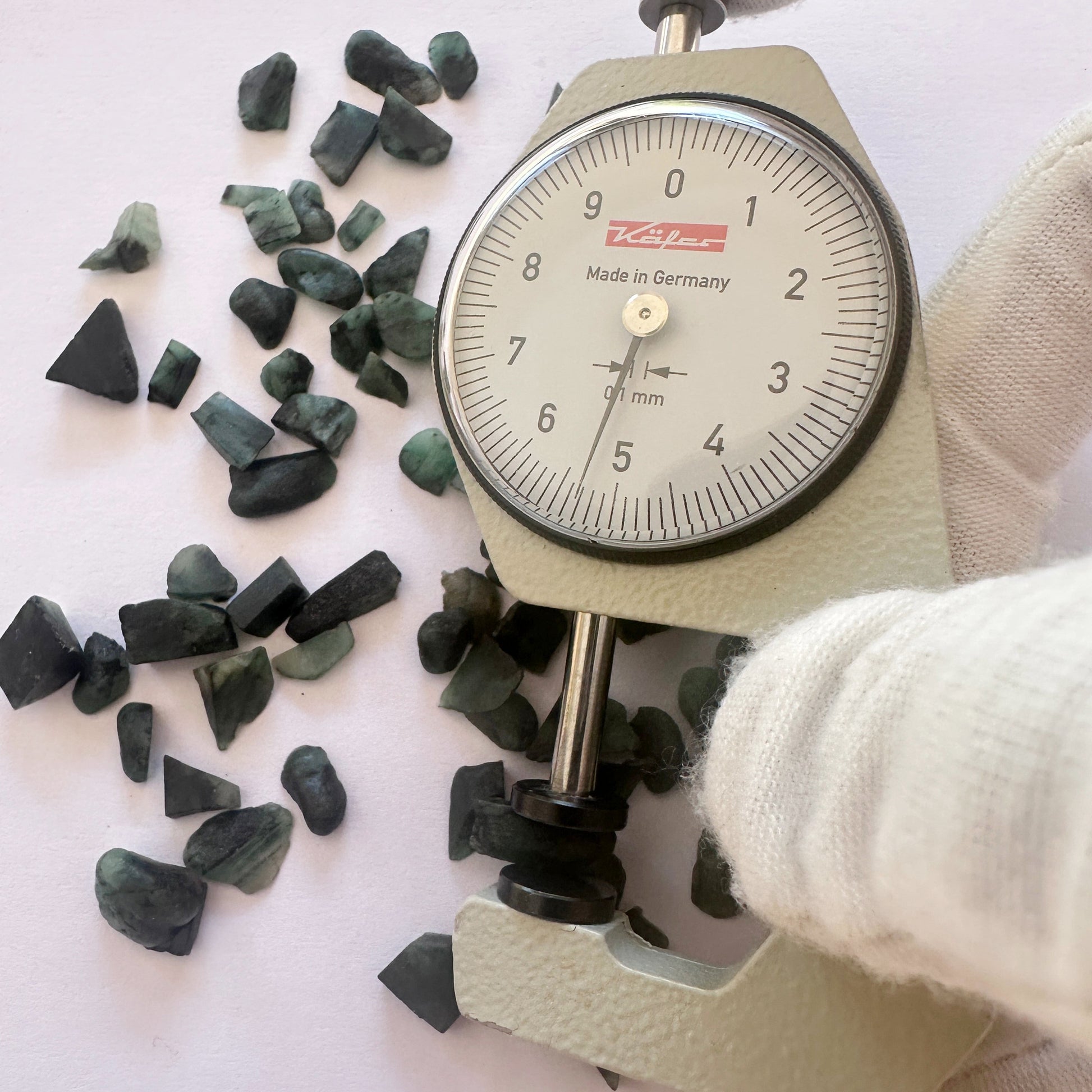 A dial gauge measures the Emerald rough  gemstone.