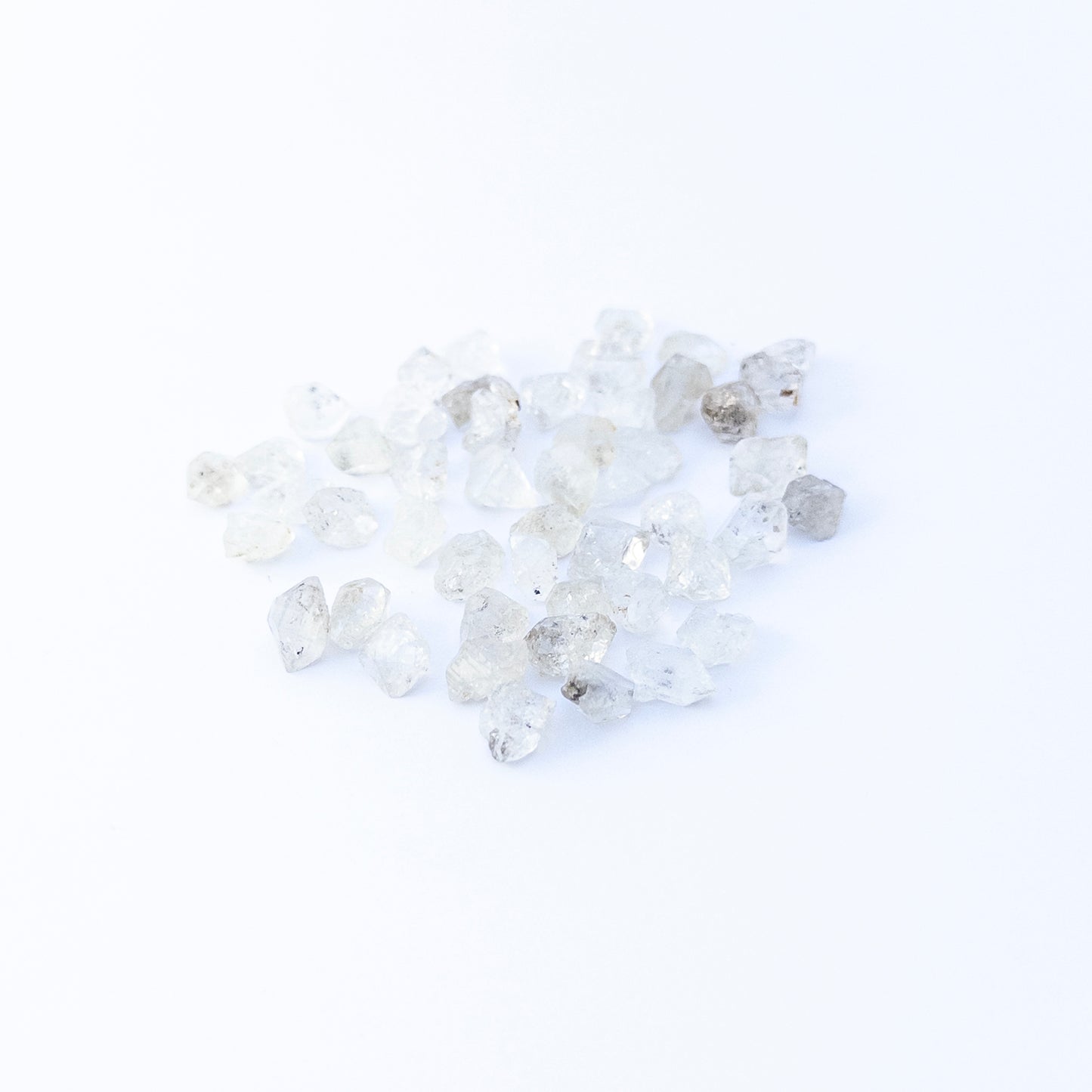 Herkimer Diamond undrilled rough crystals arranged in a group, showcasing natural clarity and bright reflective sparkle.