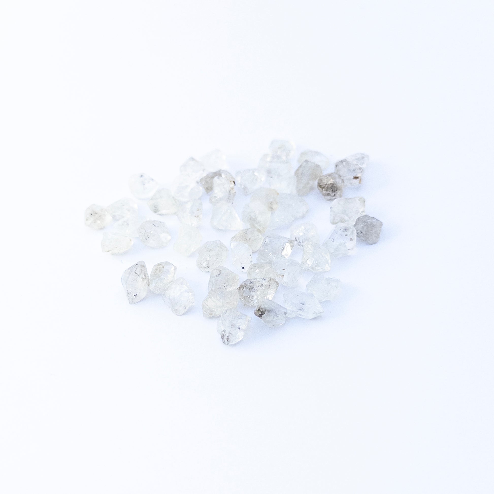 Herkimer Diamond undrilled rough crystals arranged in a group, showcasing natural clarity and bright reflective sparkle.