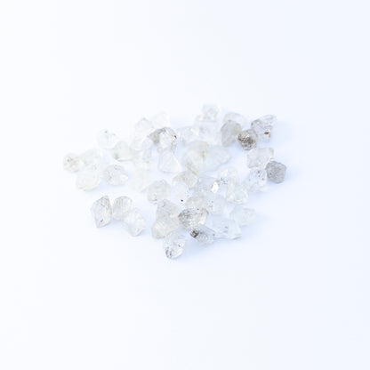 Herkimer Diamond undrilled rough crystals arranged in a group, showcasing natural clarity and bright reflective sparkle.