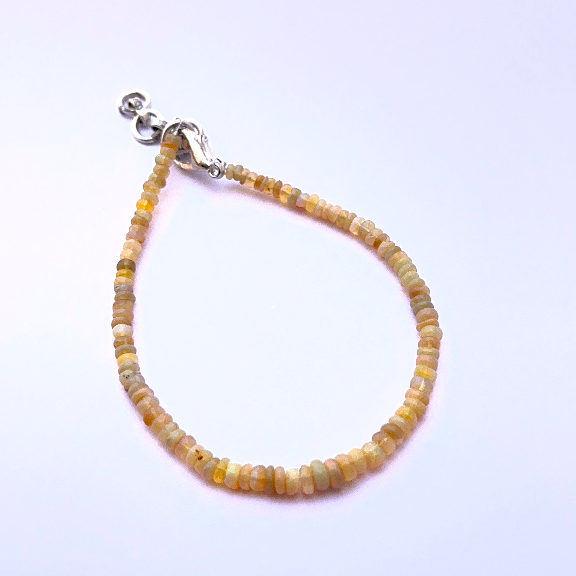 Opal bracelet with smooth beads showing natural iridescence and shine.