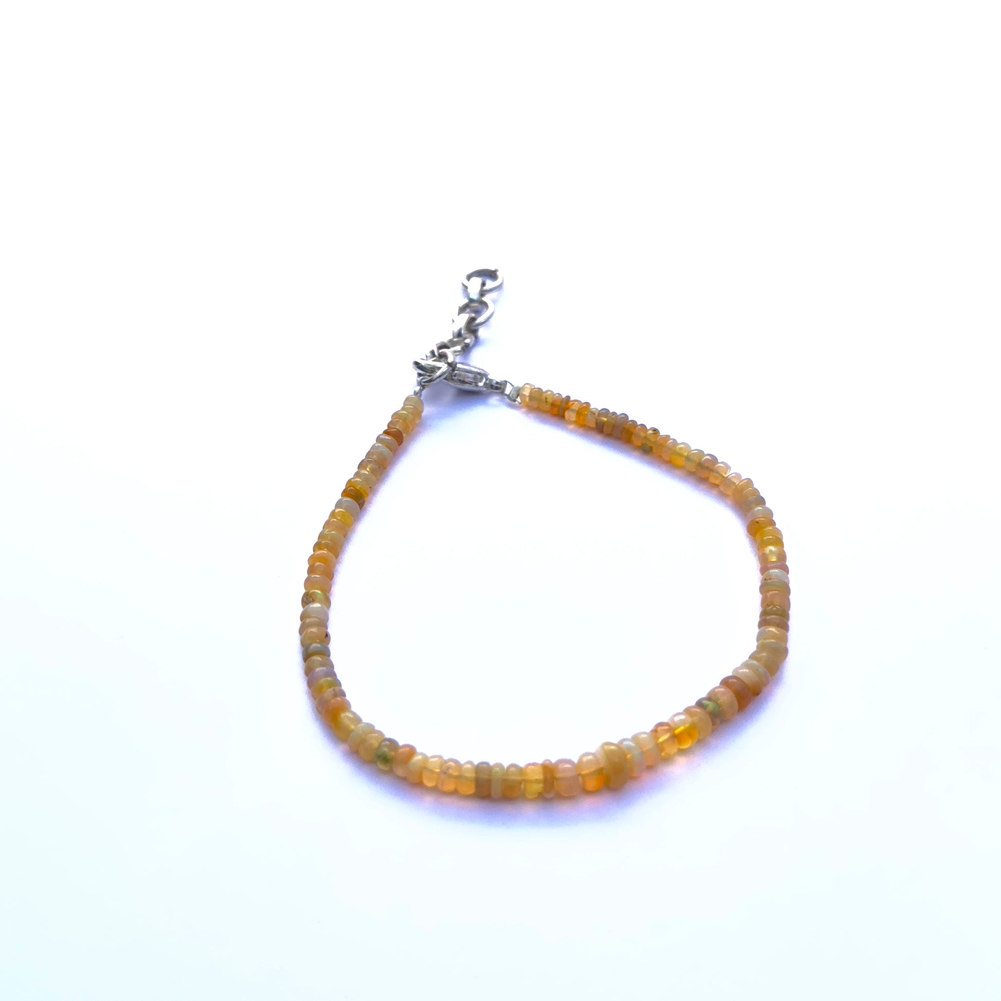 Close-up of luminous Ethiopian opal stone beads arranged in a delicate bracelet.