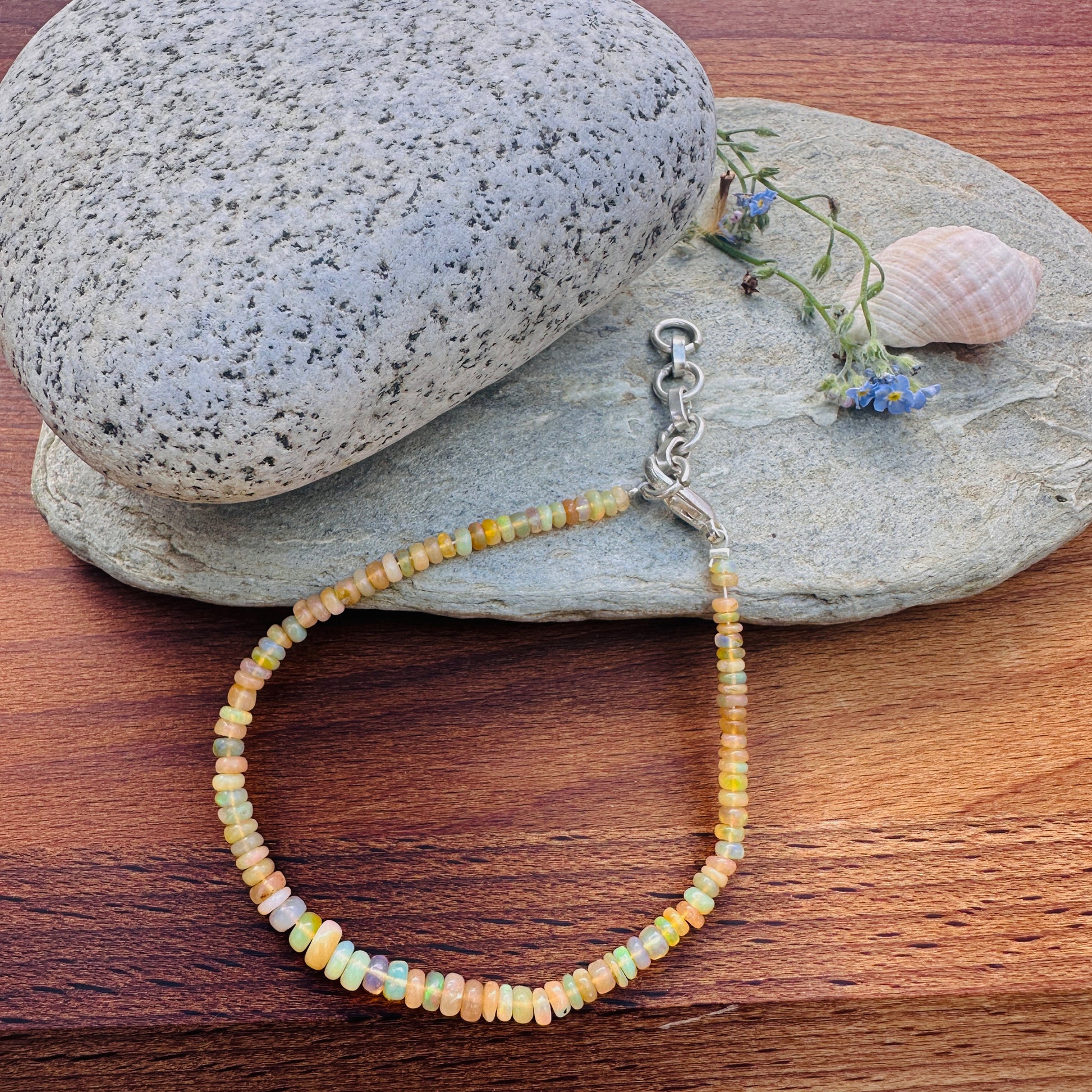 Ethiopian opal bracelet with 4mm smooth rondelle beads and adjustable lobster clasp.