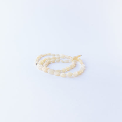 Handmade jewellery components featuring carved Ethiopian Opal oval beads in a neatly arranged strand.