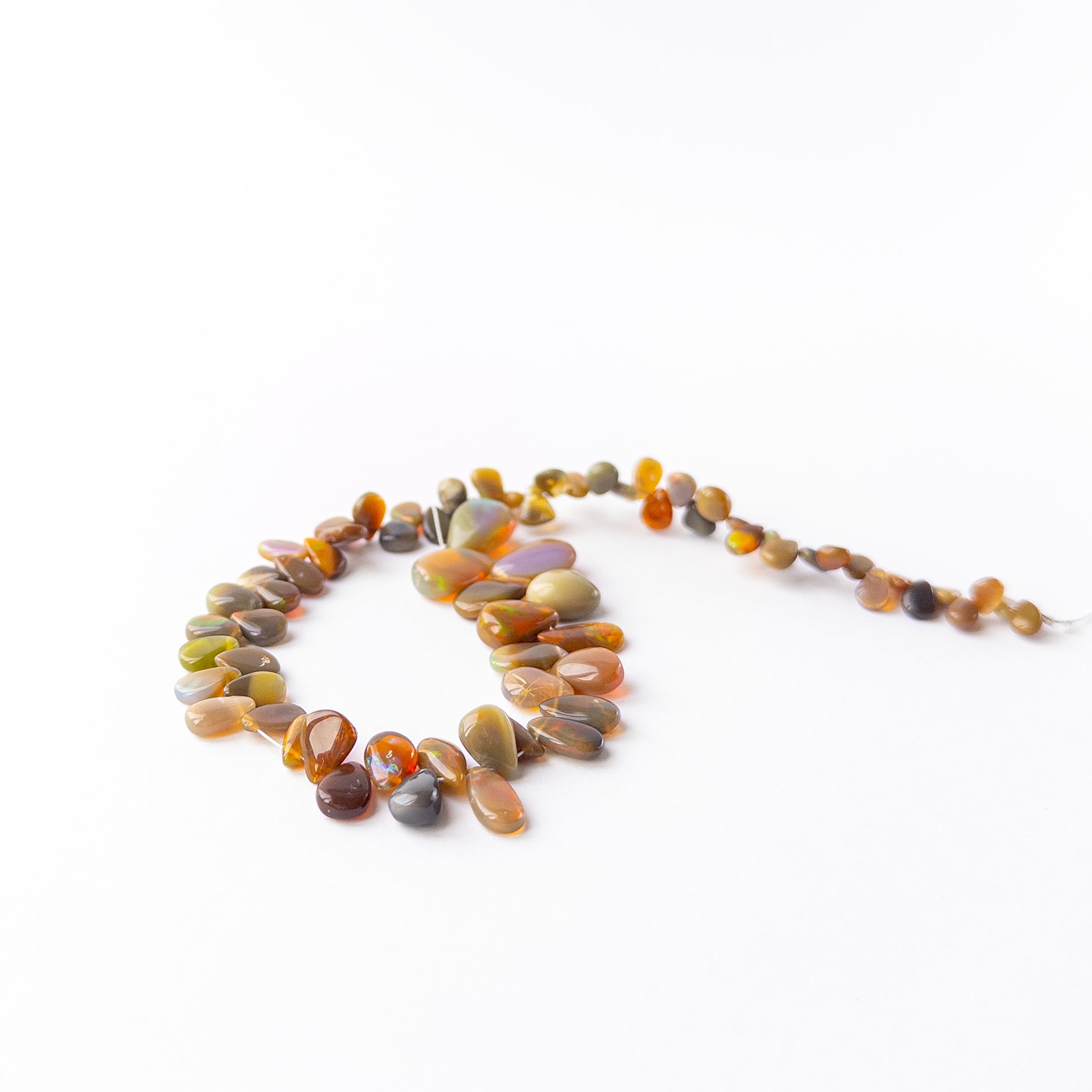 Ethiopian Opal smooth briolette beads displaying soft translucency and radiant pastel tones.