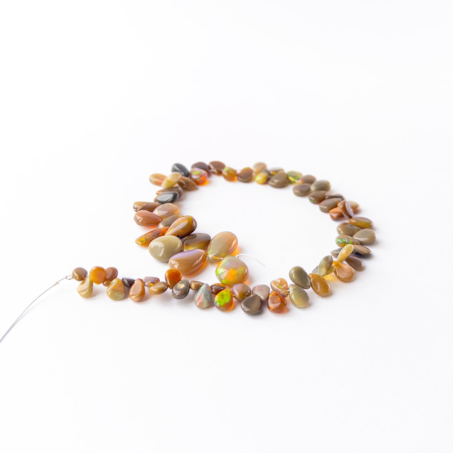 Ethiopian Opal briolette beads showcasing their glossy finish, colour variation and craftsmanship.