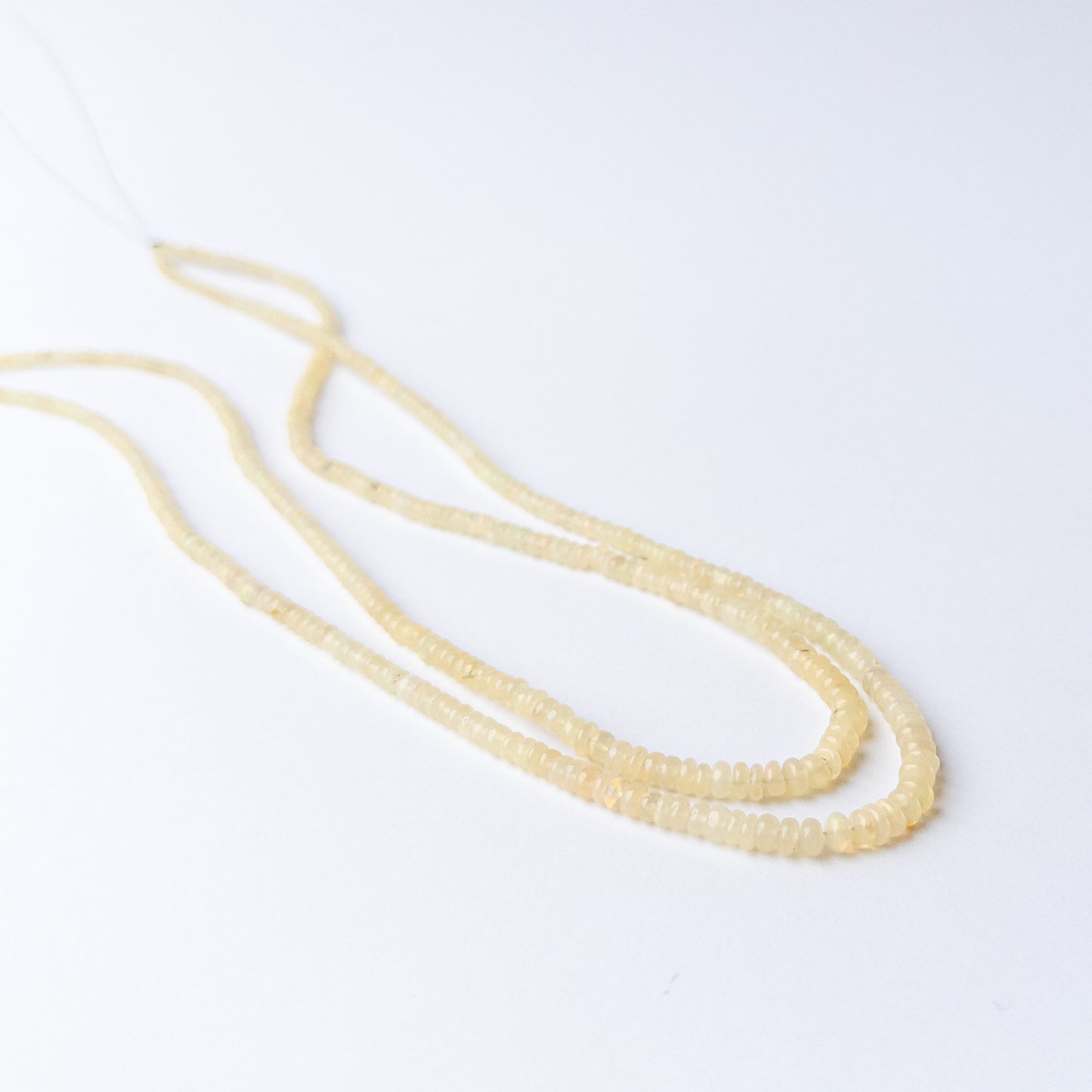 High‑quality Ethiopian Opal rondelle beads arranged neatly for artisan jewellery designs.