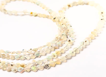 Ethopian Opal rhombus beads featuring smooth surfaces, geometric form, and consistent 3.5–6.5mm sizing.