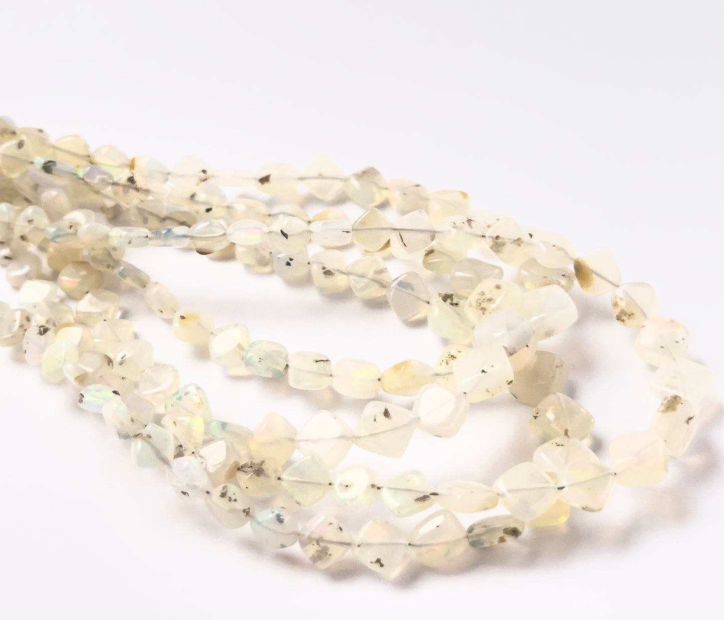Ethopian Opal smooth rhombus beads, showing their geometric design and glowing colour play.
