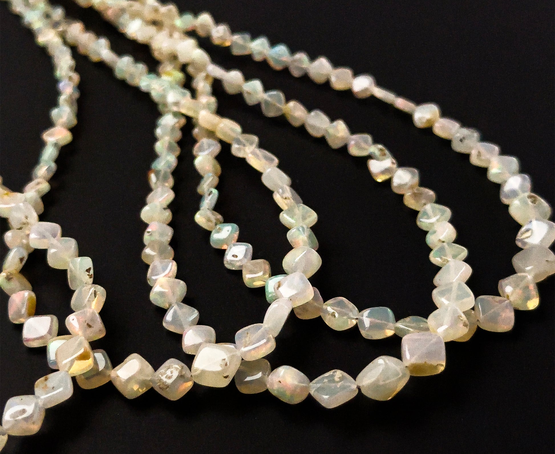 Ethopian Opal rhombus gemstones sized 3.5–6.5mm, arranged in a polished 44cm strand with uniform proportions.