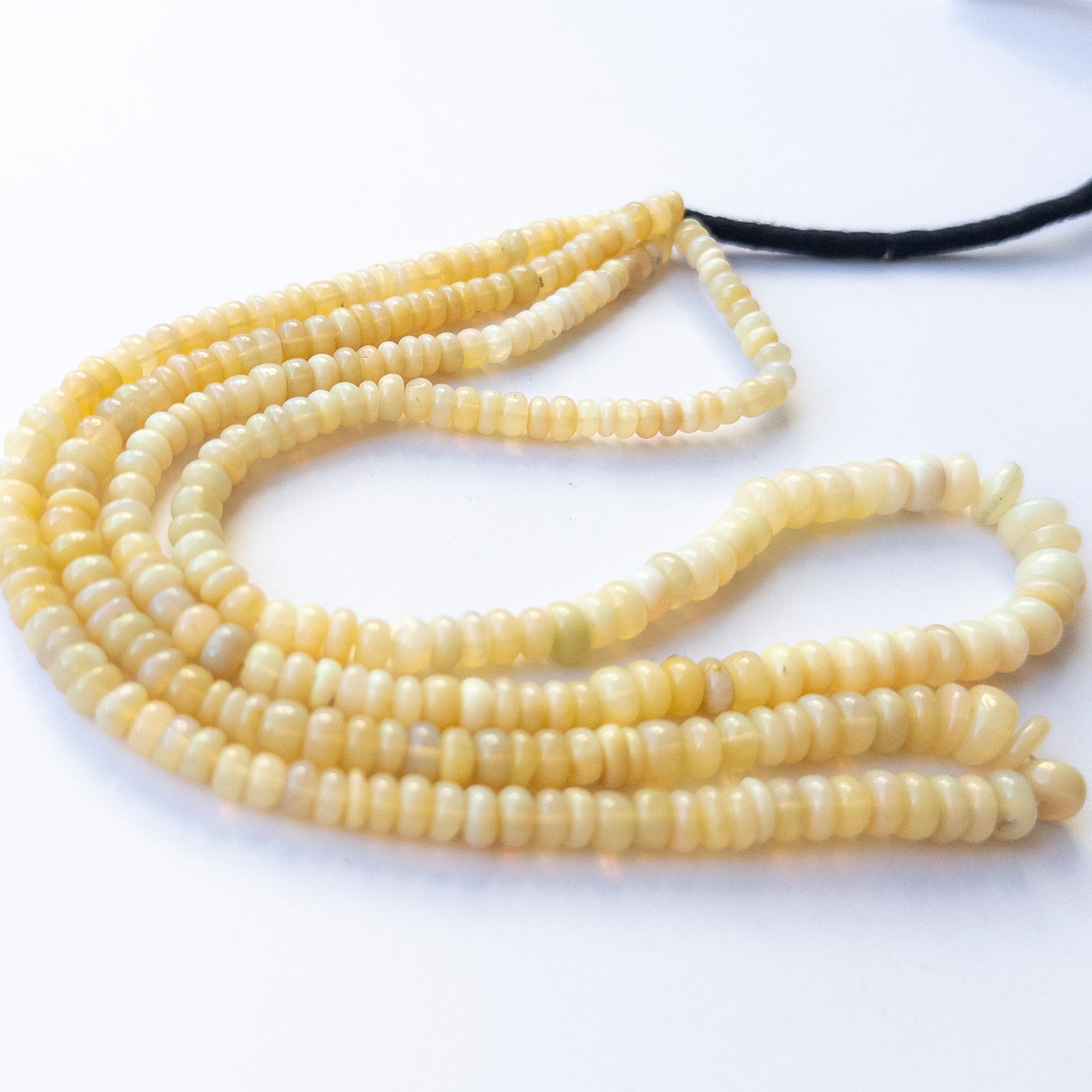 Ethopian Opal smooth wheel beads in 4.5–6.7mm, showing natural play‑of‑colour for genuine gemstone beads and handmade jewellery components.