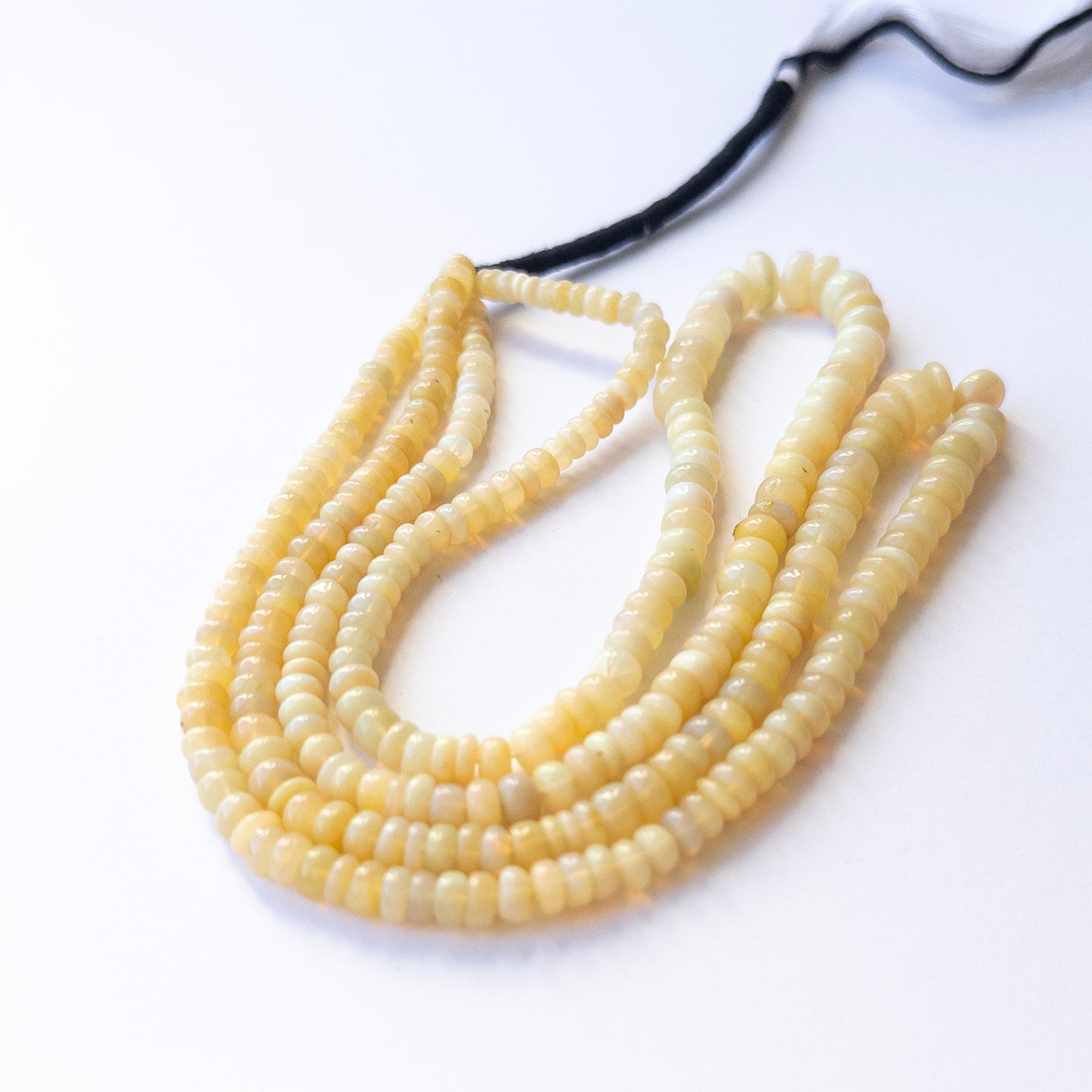 Ethopian Opal smooth wheel beads with natural colour variation, perfect for handmade jewellery components and creative beadwork.