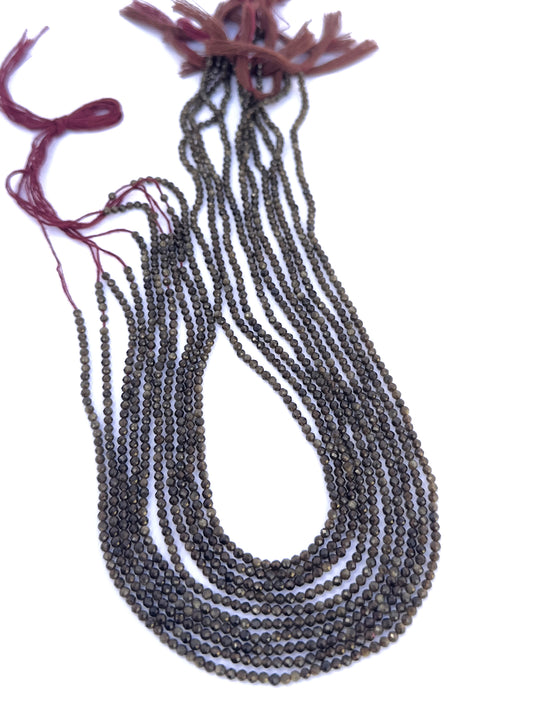 Cat’s Eye gemstone beads laid flat to highlight their faceted surface and uniform size.