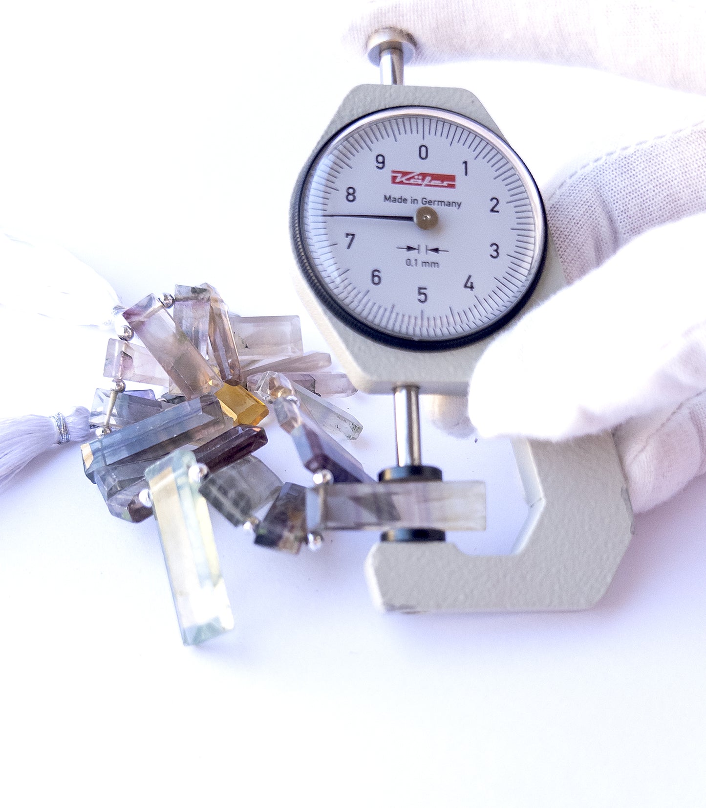 A dial gauge measures the Fluorite faceted rectangle 7–9mm gemstone.