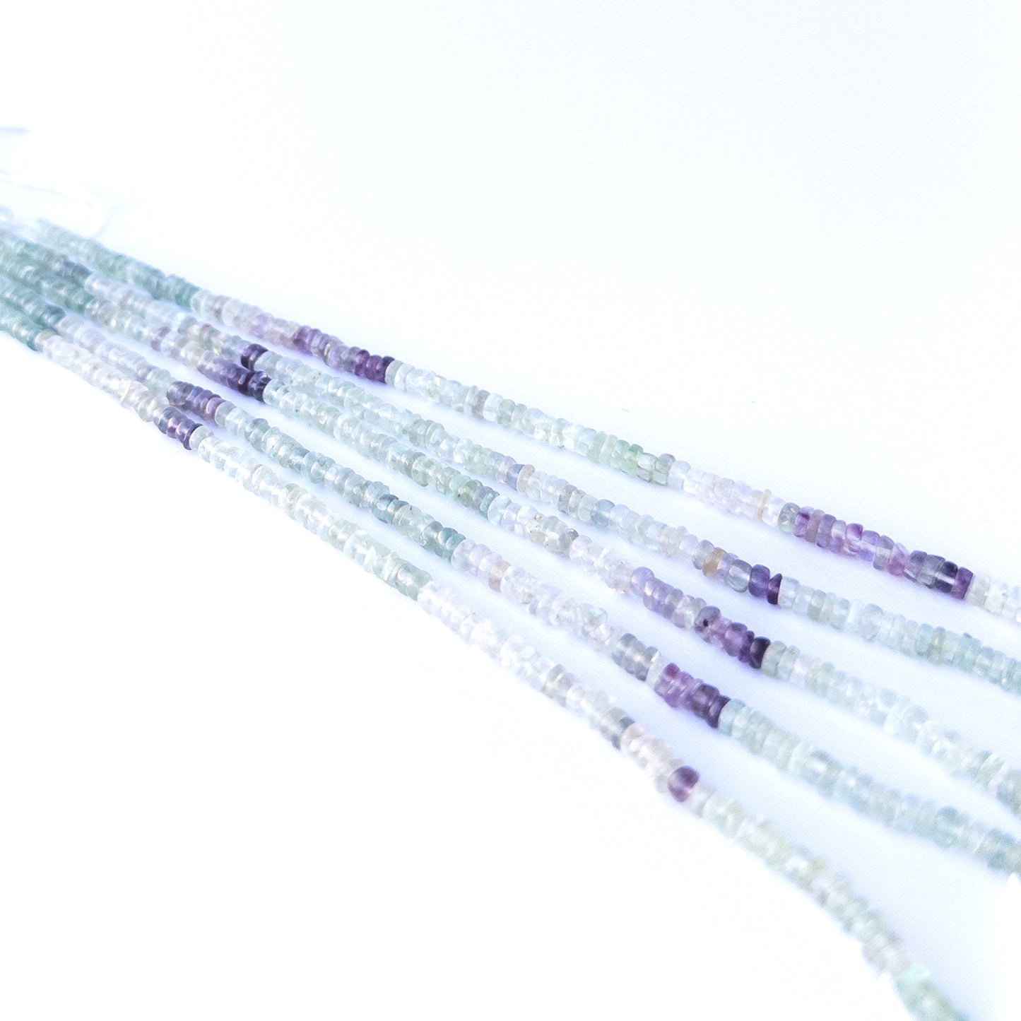 Handmade jewellery components featuring natural fluorite smooth wheels with vibrant tones and soft glow.