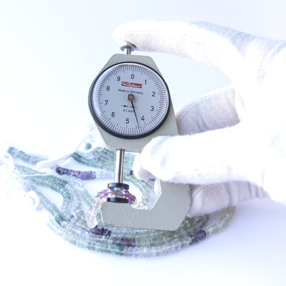 A dial gauge measures the Fluorite smooth wheel 4–4.4mm gemstone.