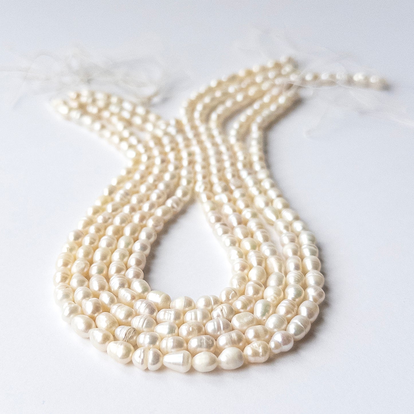 Freshwater Baroque Pearl beads arranged in a strand showing soft lustre and organic shapes.