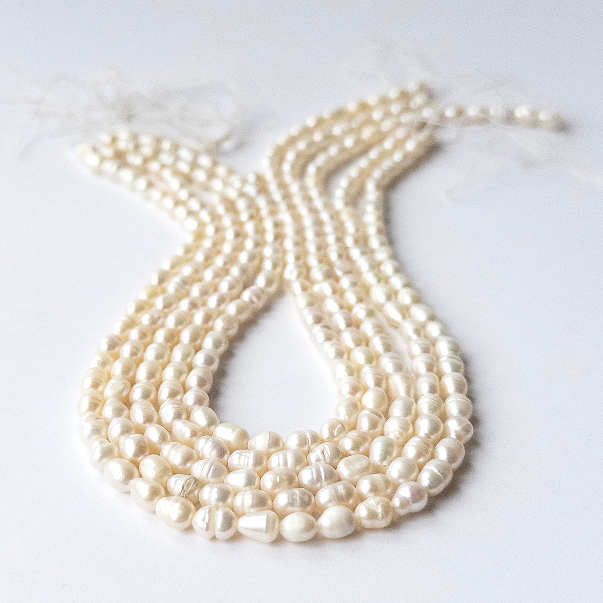 Freshwater Baroque Pearl beads arranged in a strand showing soft lustre and organic shapes.
