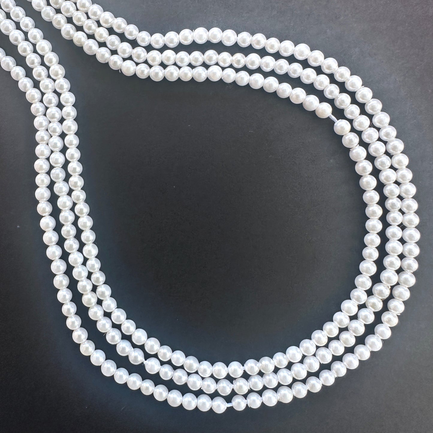 Close-up of Freshwater Pearl smooth round beads with creamy white tones and soft lustre.