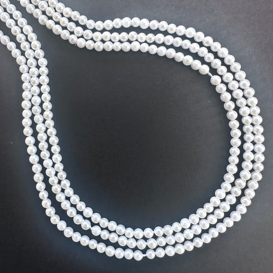 Close-up of Freshwater Pearl smooth round beads with creamy white tones and soft lustre.