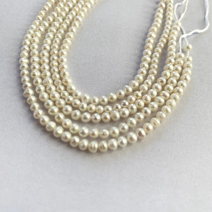 Neatly strung freshwater pearls in soft white tones, ideal for fine jewellery making.