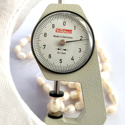 A dial gauge measures the Freshwater Pearl Baroque cut 10 x 7.7mm to 12.5 x 8.0mm gemstone.