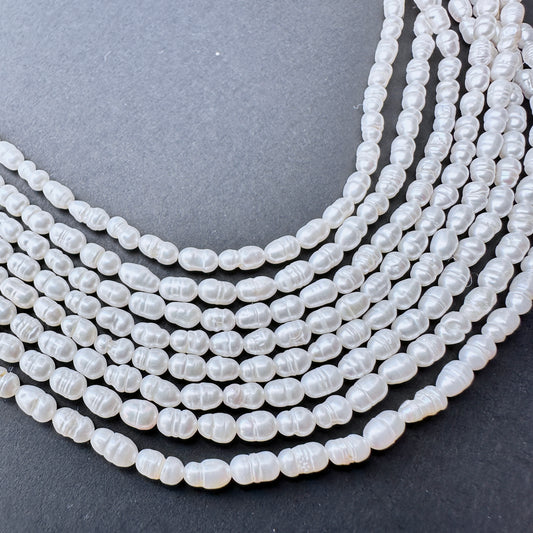 Freshwater Pearls in baroque rice shapes with soft lustre arranged on a 39cm strand for jewellery making.
