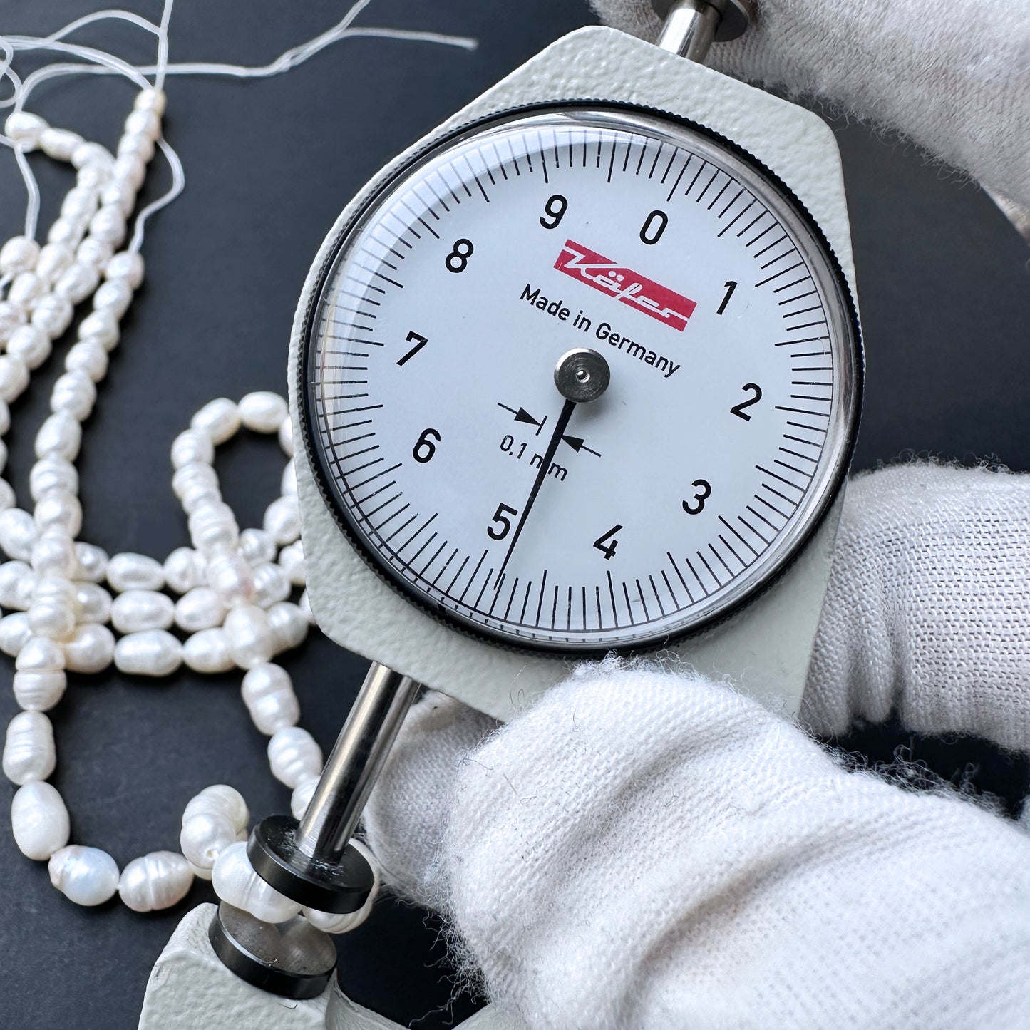 A dial gauge measures a baroque rice shaped Freshwater Pearl.